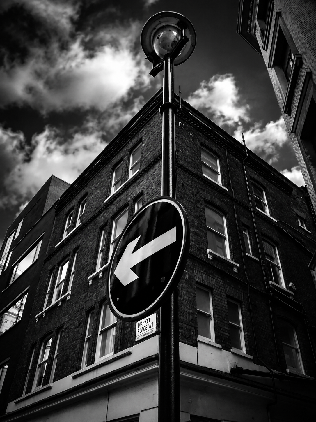 Directional sign against city architecture