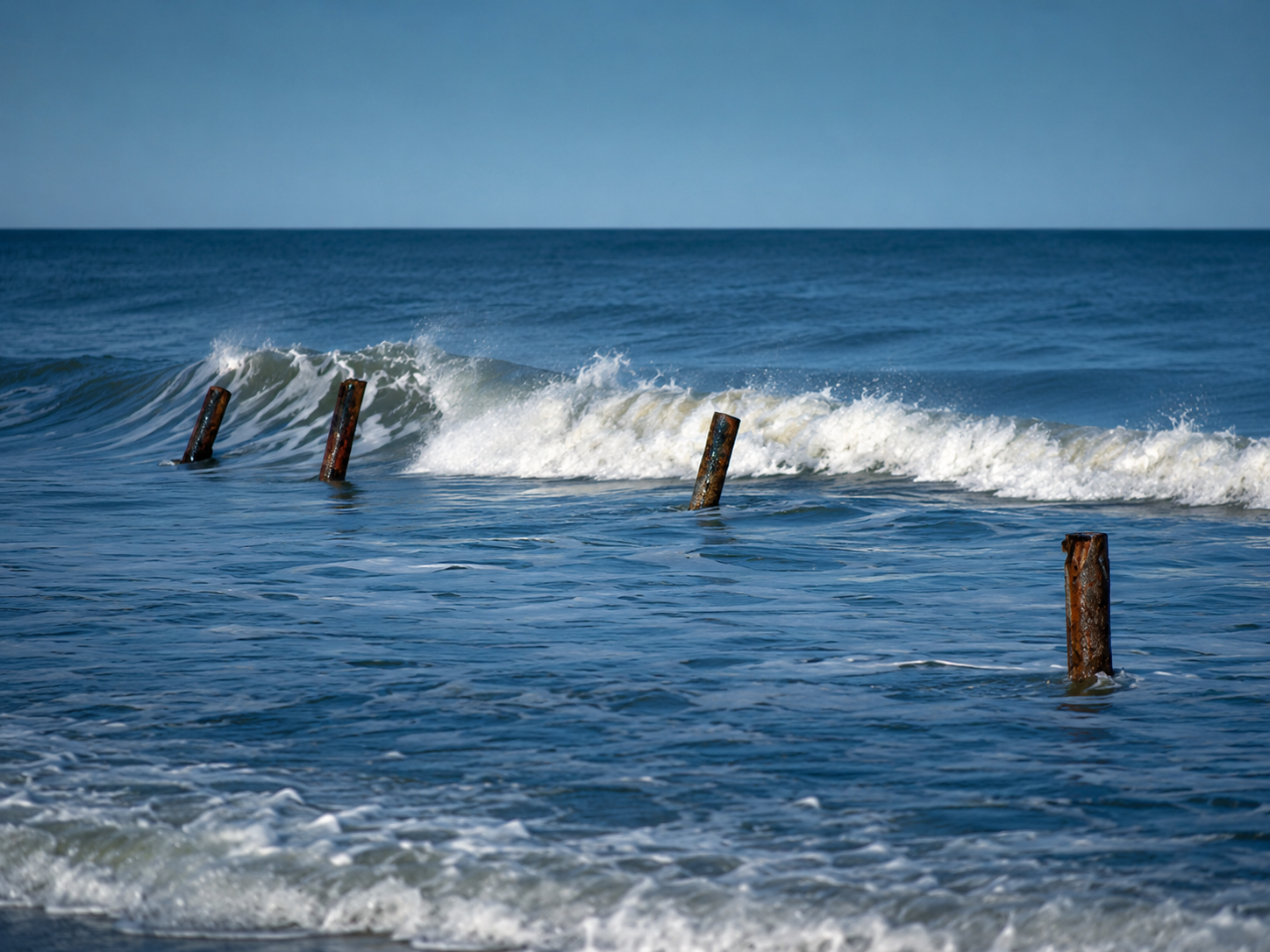 Waves moving through weathered posts